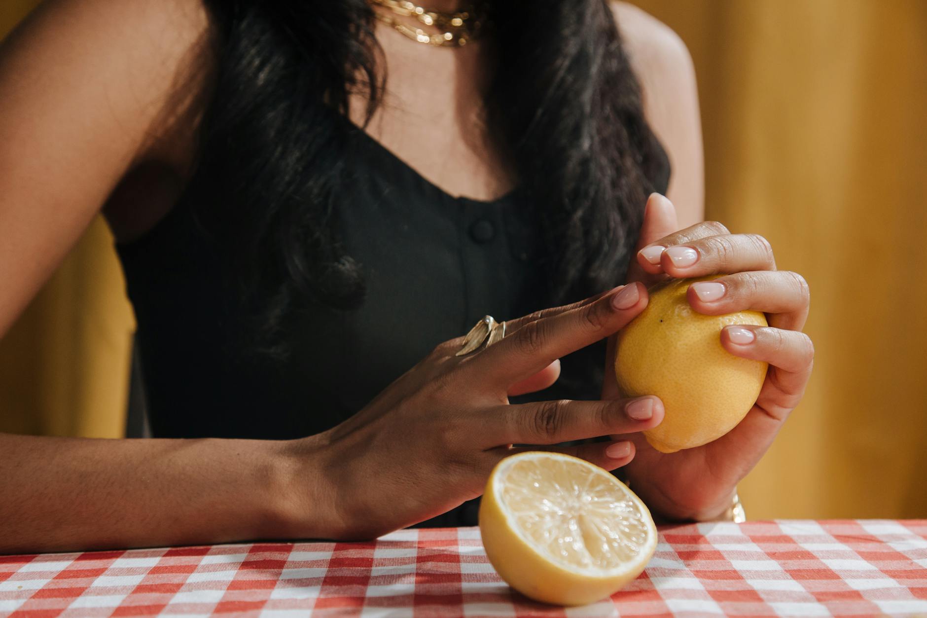 Close-up of woman holding a fresh lemon, representing renewal and fresh starts after stress