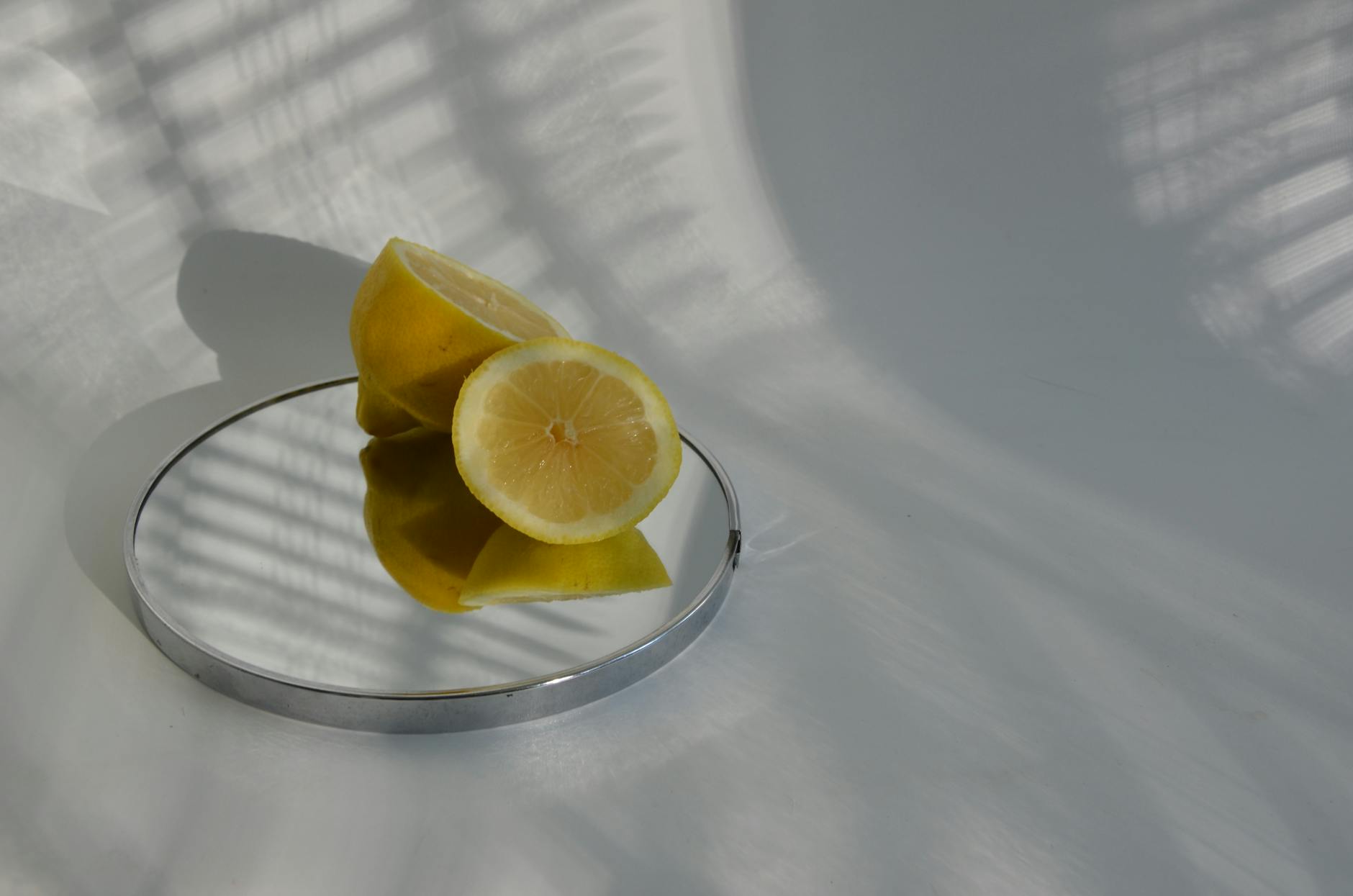 A blue clitoral vibrator surrounded by flowers and citrus slices on a bright yellow background.