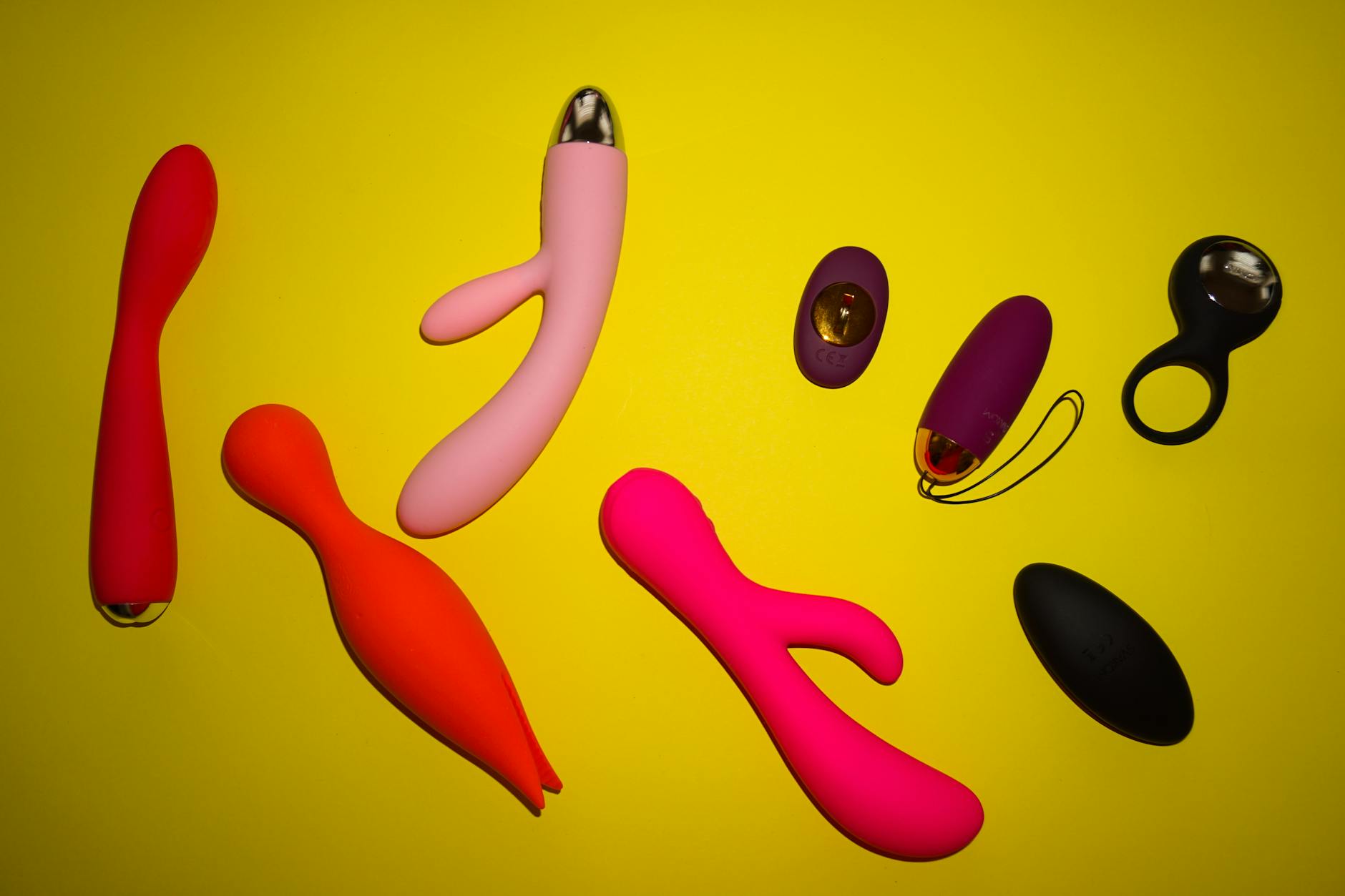 Close-up of a blue silicone vibrator held in hand against a solid purple background