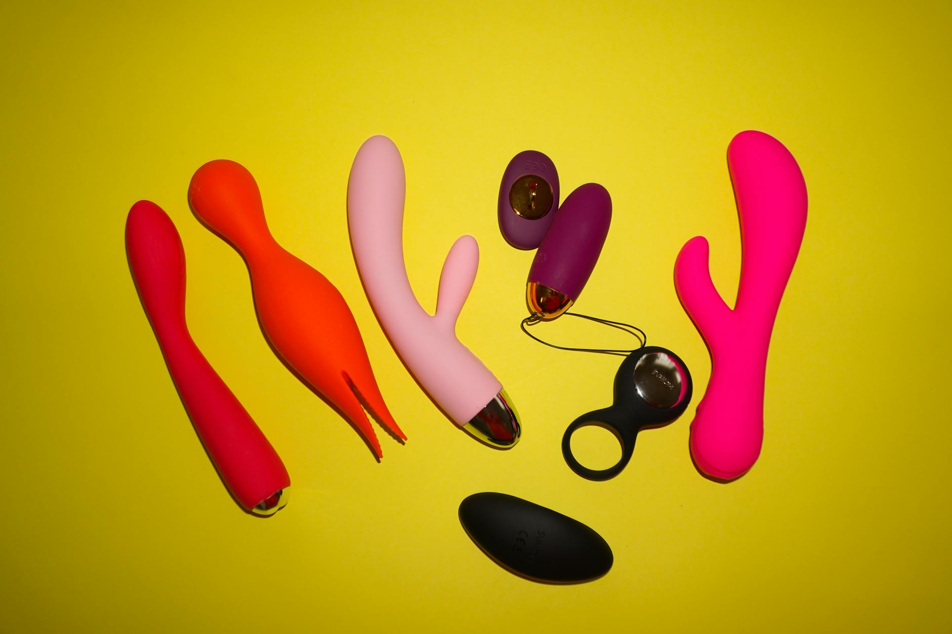 Colorful silicone vibrators and adult toys displayed on a bright background